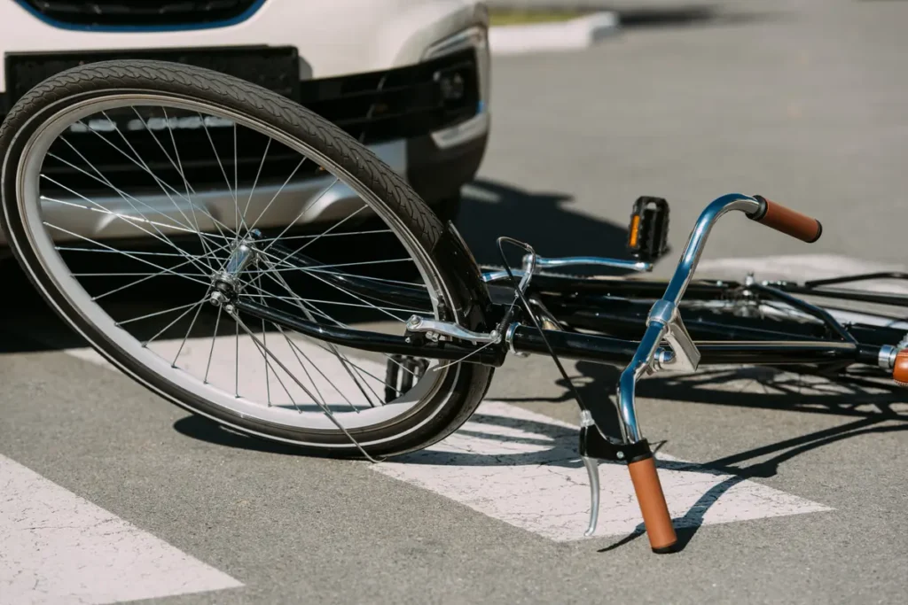 Bicycle lying in a crosswalk next to a car