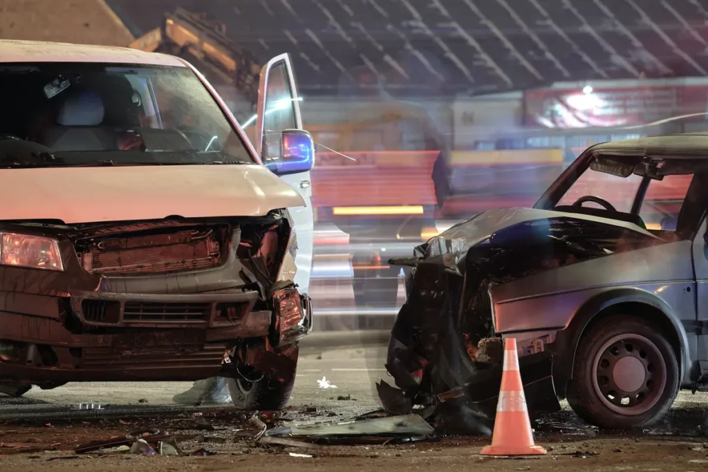 Two damaged cars at night after a crash
