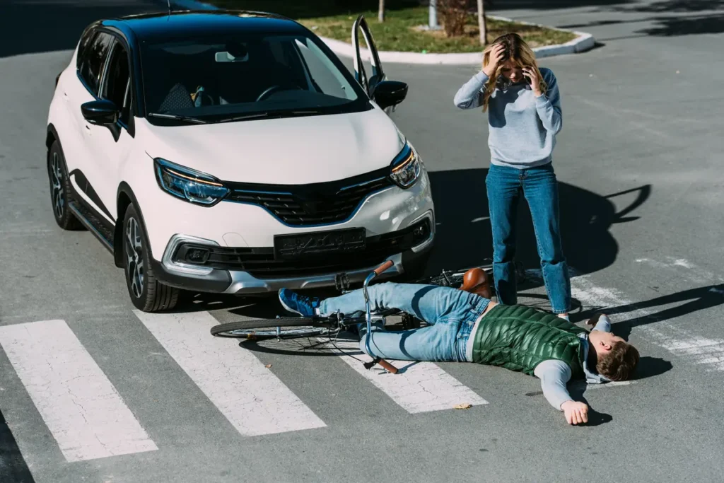 Cyclist lying in a crosswalk after being hit by a car