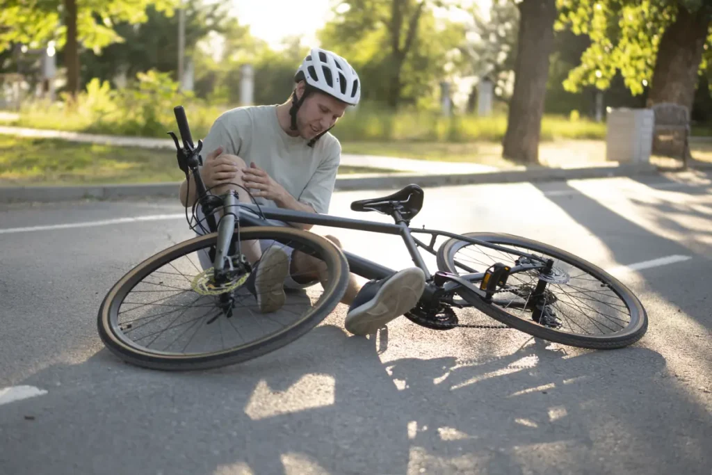 Cyclist holds his injured knee after a fall