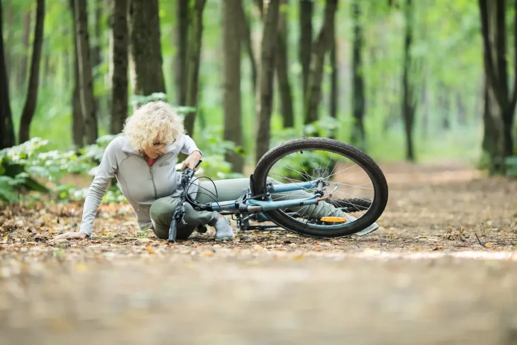 Woman fallen with her bike on a trail