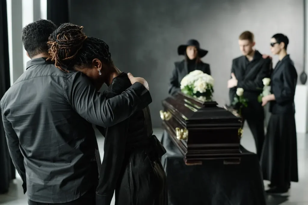 Mourners hold each other at a funeral service