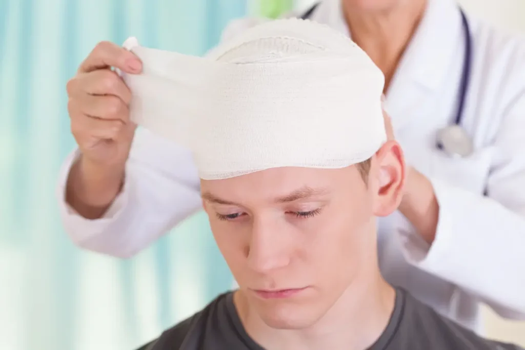 Young man gets a head bandage from a doctor