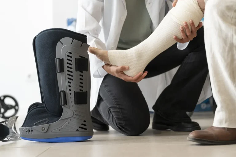 Doctor fits a walking boot on a patient's injured leg