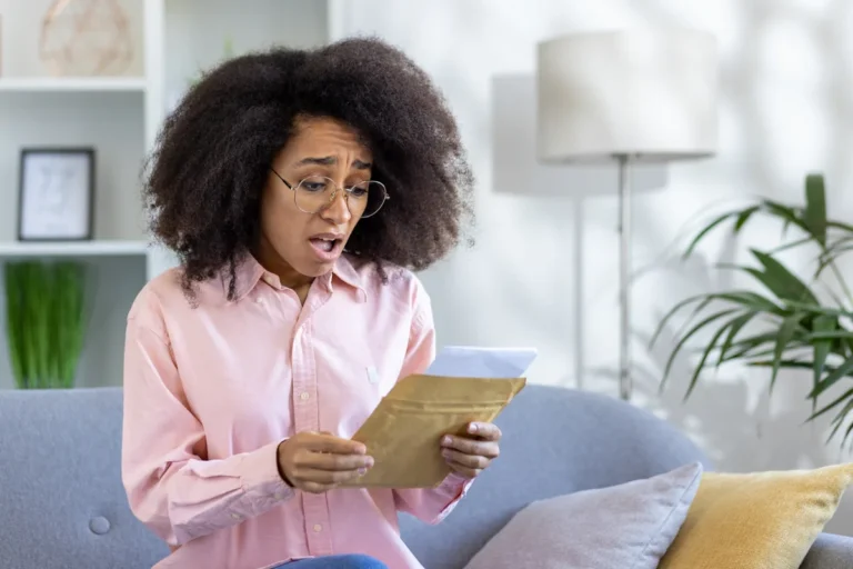 Woman looks surprised reading an insurance letter at home