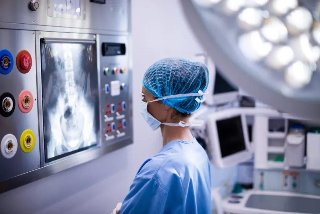 Surgical nurse reviews an X-ray in an operating room