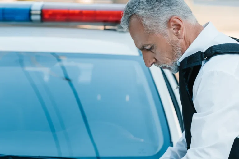 Officer writes a collision report on the hood of a police car