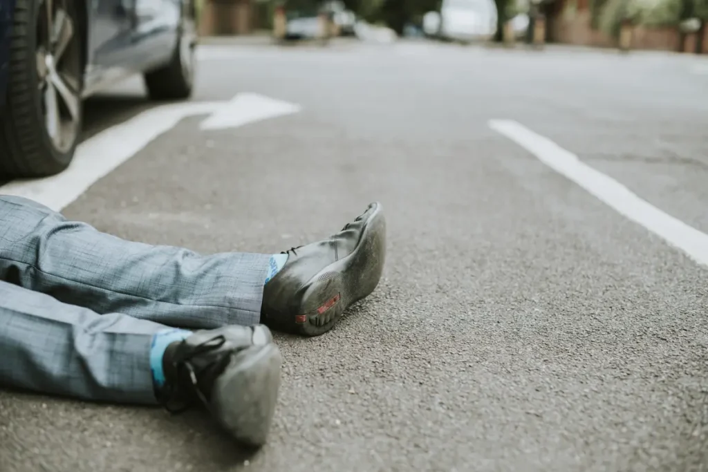 Person lying on the street after being hit by a car