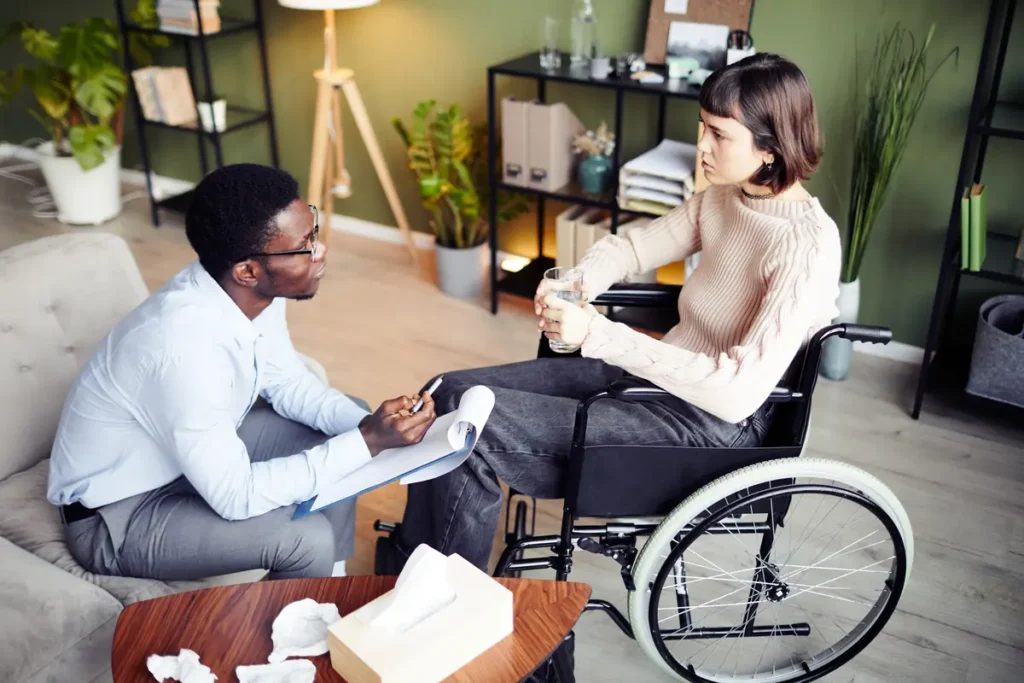 Woman in a wheelchair meets with a professional at home