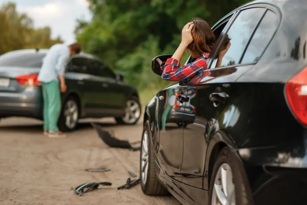 Hurt driver leans out of her car after a crash